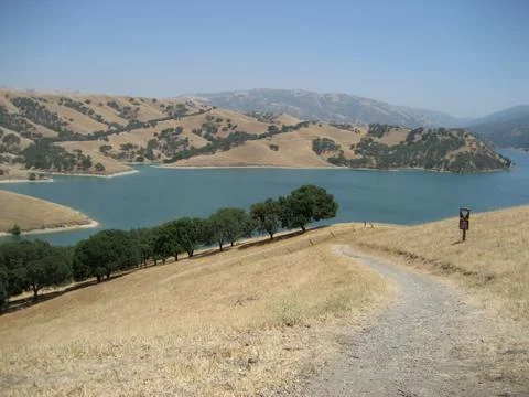 Dirt path leads down toward a lake Stock Photos