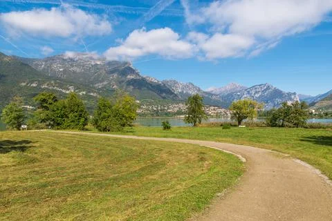 Dirt path through meadows, on a lake. Lake Annone or lake Oggiono, Italy Stock Photos