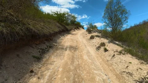 Dirt path winds through green, sunlit hills. Balkan, Eastern Europe, POV Video stock 333588383
