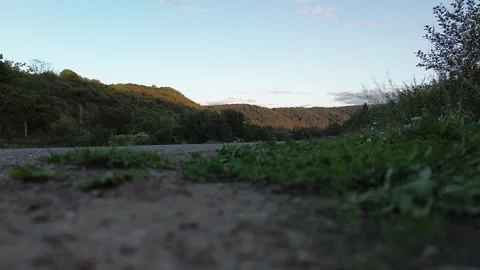Dirt path winds through green hills at dusk Stock Footage 345277241