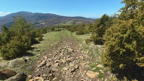 Dirt path winds through rocky hillside. Balkan, Eastern Europe, POV Vídeos de archivo 333441493