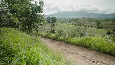 The dirt road between to a distant village with hill layer and huge mountain Stock Footage 154190019