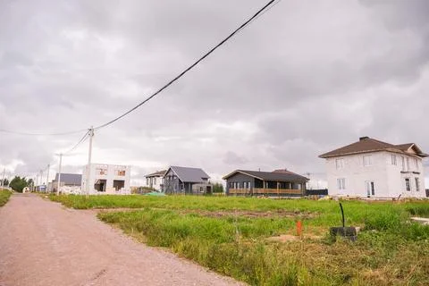 Dirt road leading through a developing suburban neighborhood with residential Foto stock