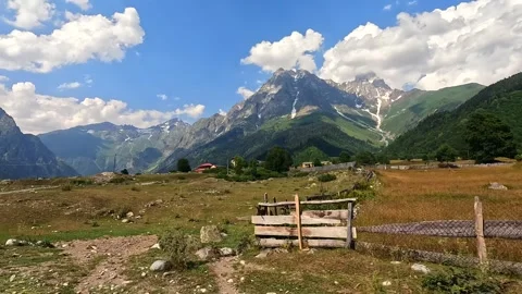 Dirt road leads toward Ushba, wide landscape view across Mazeri village Stock Footage 343774427
