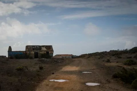 Dirt road passing through an abandoned house Stock-Fotos