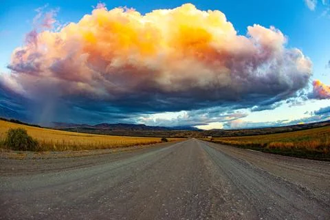 The dirt road Ruta 40 in Patagonia Colossal picturesque thundercloud is pi... Stock Photos