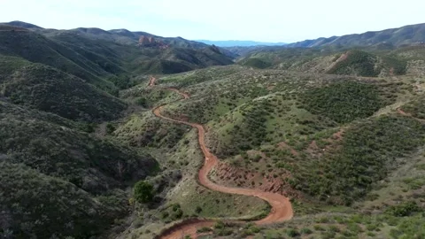 A dirt road winds through a mountain range Stock Footage 306416988