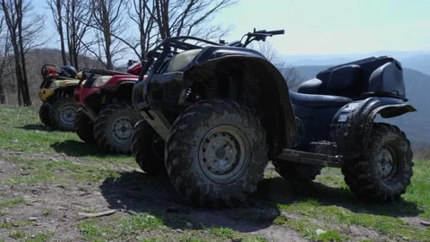 Dirty ATVs stand against backdrop of mountain peaks Touring rides on a quad bike Stock Footage 180486003