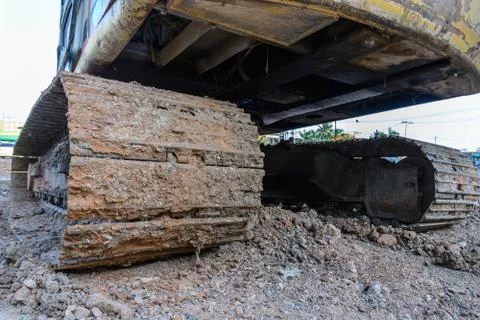 Dirty back hoe track at construction site. Stock Photos