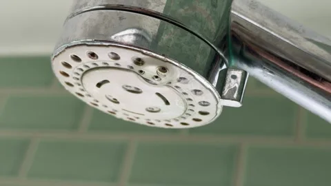Dirty bathroom showerhead dropping clear liquid 4K Stock Footage 332023675