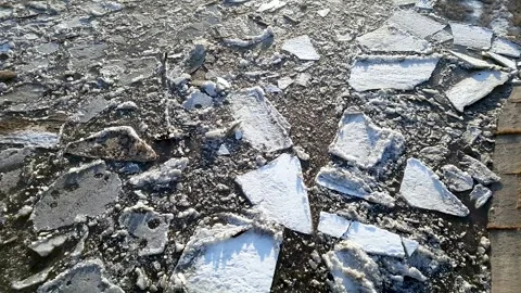 Dirty blocks of ice float along the concrete fortification of the coast. Stock Footage 240334260