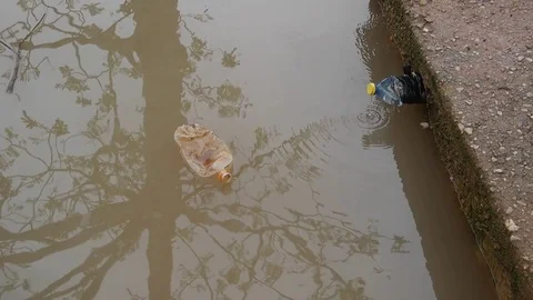 Dirty bottle floating near the spring tap Stock Footage 80425670