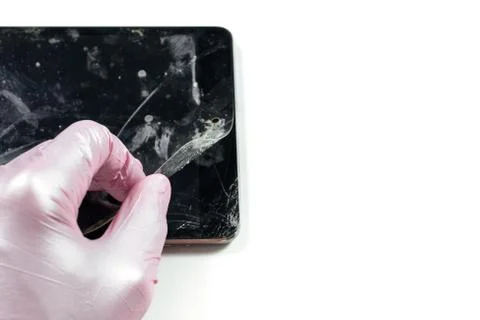 Dirty broken tablet screen. Hand removing protective film Stock Photos