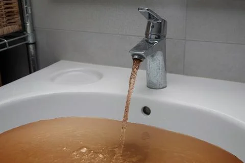 Dirty brown tap water after floods Stock Photos
