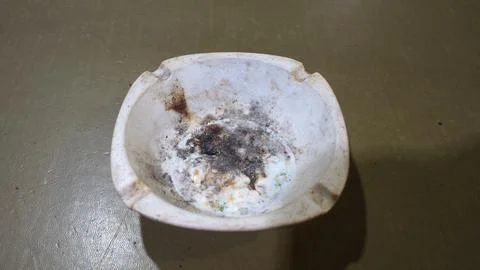 Dirty ceramic ashtray on table Stock Photos