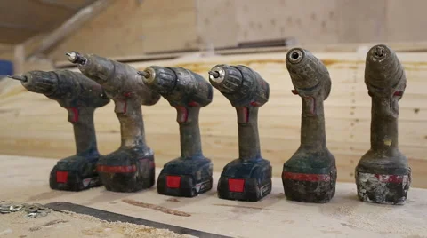 Dirty cordless rechargeable screwdrivers stand in a row Stock Footage 59783252