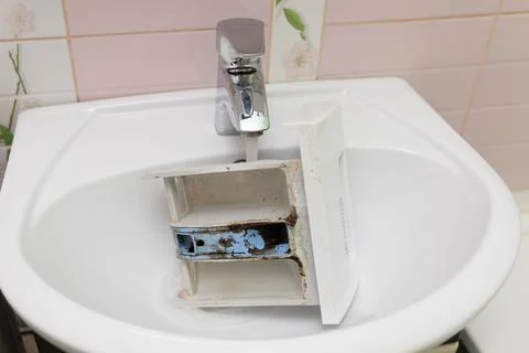 Dirty, corroded laundry machine dispenser for wash powder detergent with dregs Stock Photos
