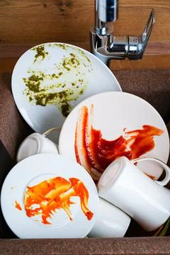 Dirty dishes, dirty white plates in the kitchen sink Stock Photos