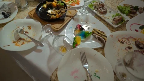 Dirty dishes with leftover food on the holiday table. Messy table after party Stock Footage