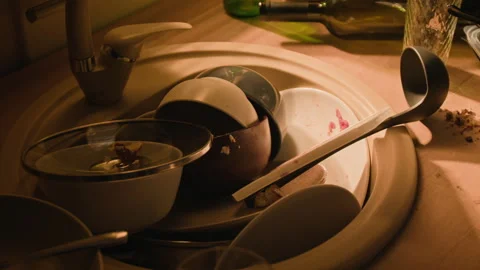 Dirty Dishes Piled in Messy Kitchen Sink with Empty Wine Bottle Stock Footage 344866695