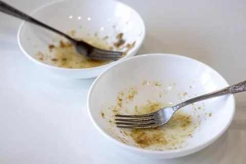 Dirty dishes, selective focus. Two white bowls and forks. Stock Photos