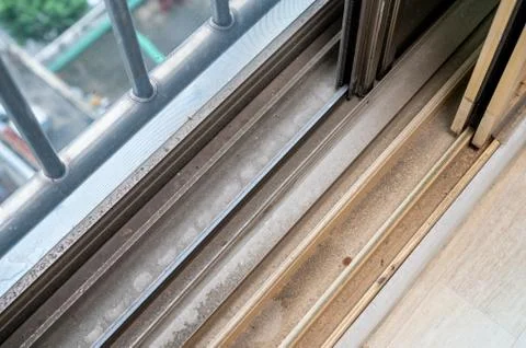 Dirty dust piled up in plastic window frames. Stock Photos