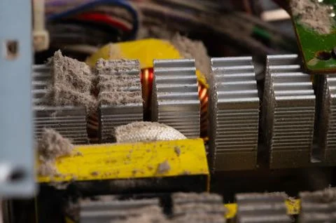 Dirty elements of the pc power supply in dust. Aluminum radiator with pieces of Stock Photos