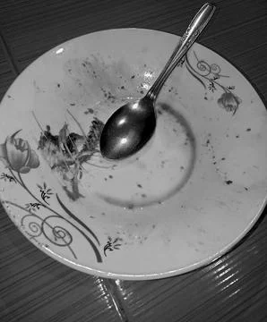 Dirty Empty Plate with Leftover Fish Bones and Spoon in Black and White Stock Photos
