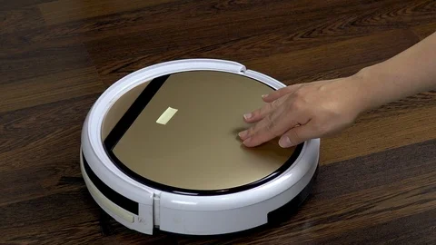 A dirty filter is pulled out of a vacuum cleaner robot. Automatic white round Stock Footage 123550966