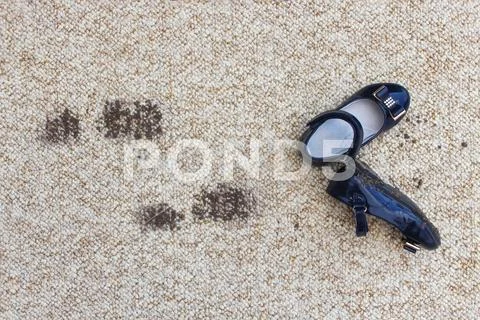 Dirty floor and children's shoes. Concept of child soiled carpet. Stock Photos