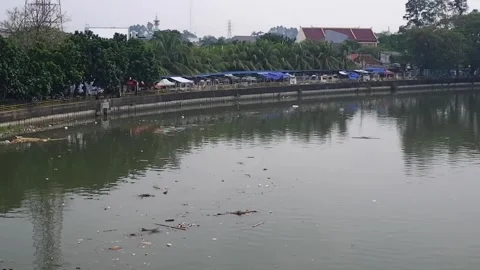 The dirty flow of the Cisadane River with murky colors and debris floating on it Video stock 303390351