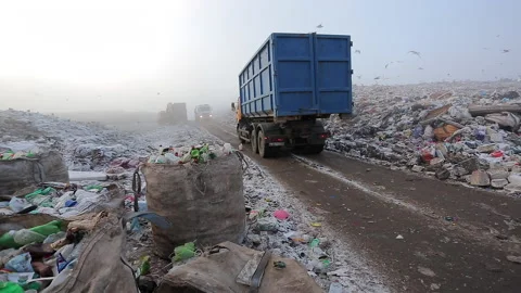 A dirty garbage truck pulls into a large city waste dump. Stock Footage 230016123