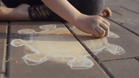 Dirty girl draws silhouette of a corona virus with a chalk on a pavement Stock Footage