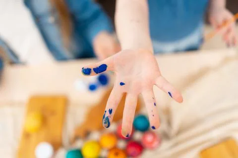 Dirty hand after decorated Easter eggs with paints. Easter tradition Stock Photos