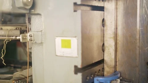 Dirty heavy machine works it produces plastic parts of complex product Stock Footage 115934868