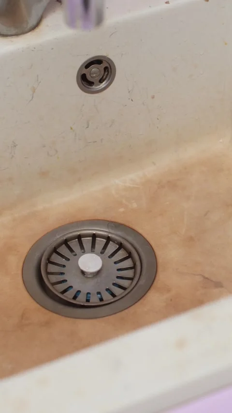 Dirty kitchen sink with visible stains and metal drain, highlighting need for Stock Footage 320875508