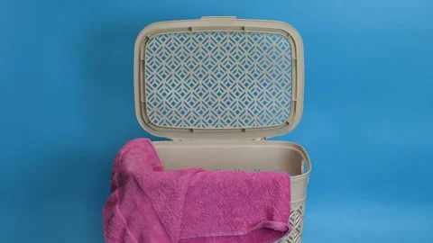 A dirty laundry towel is thrown into a container for stale laundry on a blu.. Stock Footage 232497660
