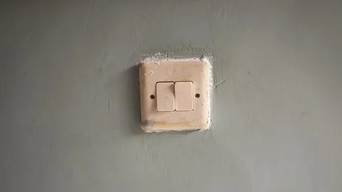 Dirty light switch stuck to the wall Stock-Fotos