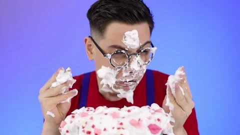 A dirty man with glasses eats a sweet dessert made of cream and sweets Stock Footage 166884848