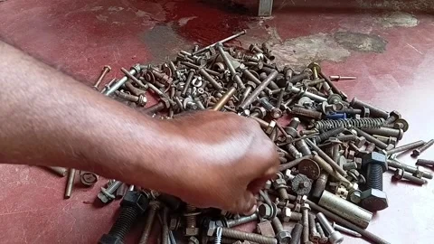 Dirty Mechanic Hand Sorting Rusty Nuts and Bolts from a Messy Pile Video stock 327553534