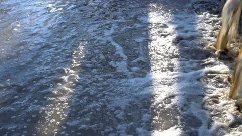 Dirty muddy water from the sewer flows like a waterfall into the river on a Video stock 166207464