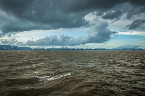 Dirty ocean waves under dramamtic sky Stock Photos