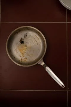 Dirty pan with extinguished cigarette. Stock Photos