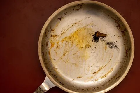 Dirty pan with extinguished cigarette. Stock Photos