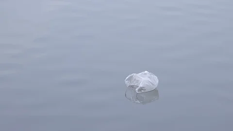 Dirty plastic bag floating in clean lake, river, sea or ocean water. Plastic Stock Footage 106151914