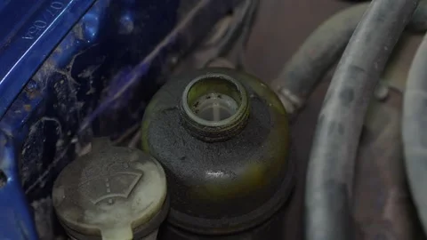 A dirty plastic car power steering reservoir tank under hood. Stock Footage 345911791