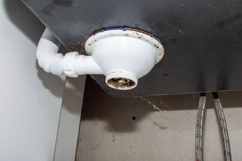 Dirty plastic drain under the kitchen sink, wear and tear, and maintenance Stock Photos