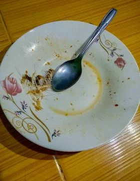 A dirty plate with spoon Stock Photos
