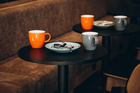 A dirty plates and an empty cups of coffee in cozy cafe interior. Foto stock