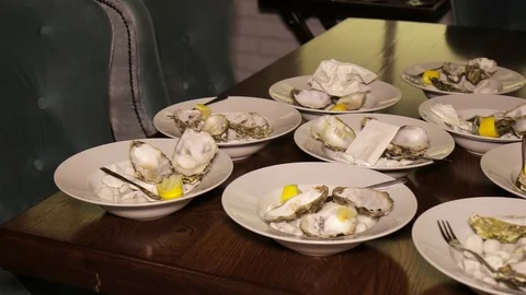 Dirty plates with empty oyster shells on a wooden table in the restaurant. Stock Footage 96357198